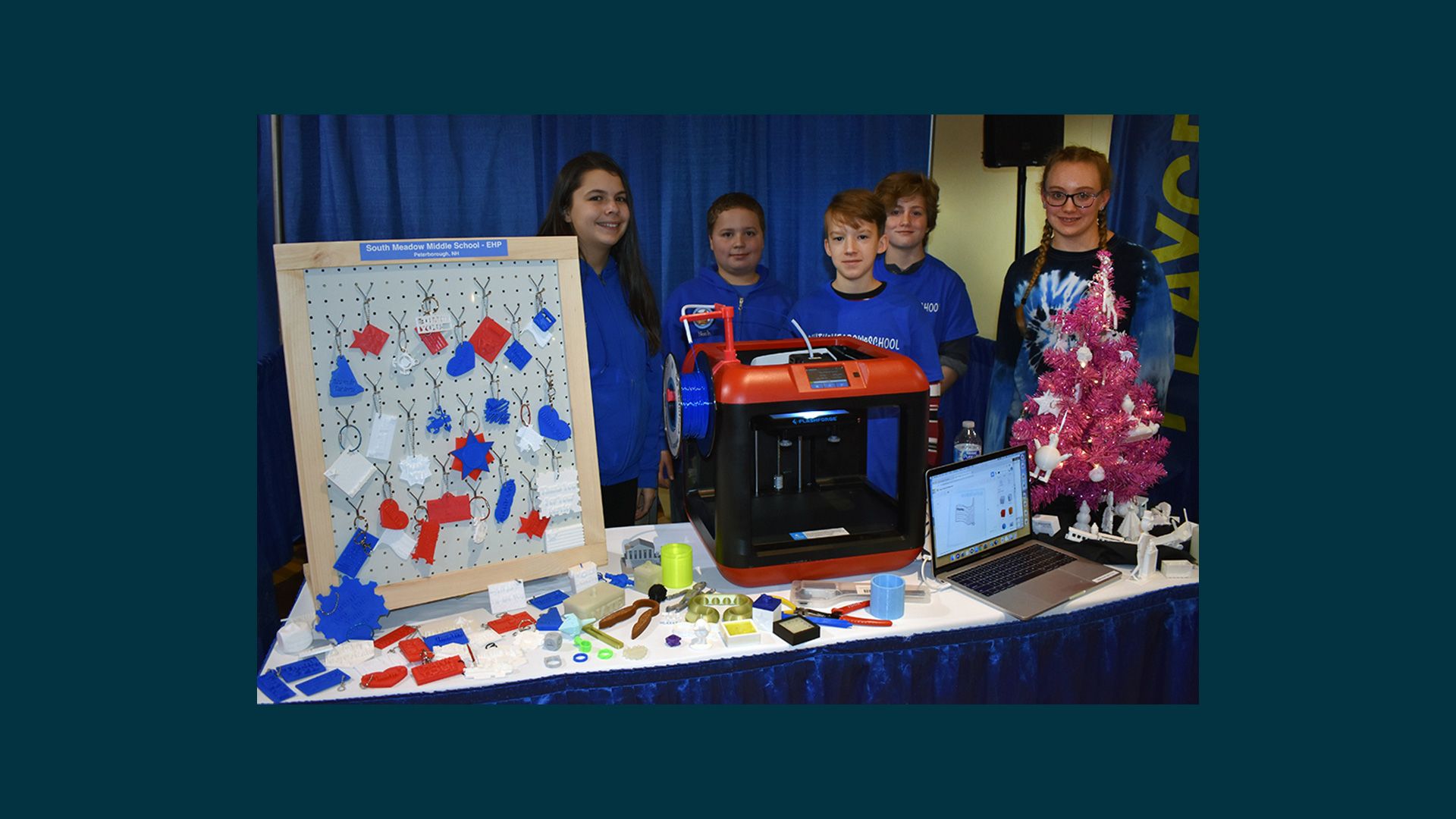 Students showcasing their 3D printed creations at a conference.