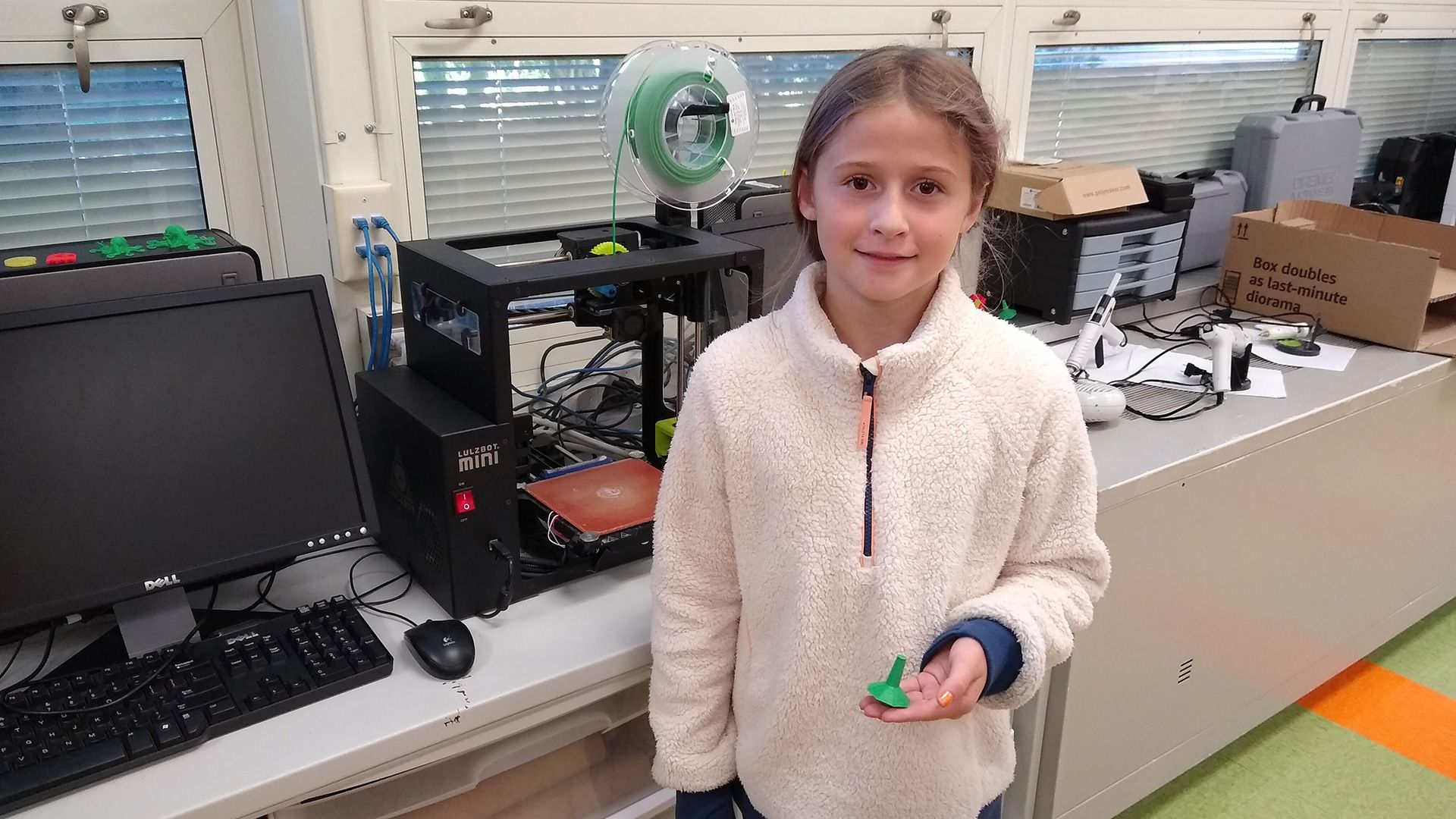 A student holding a 3D printed spinning top.