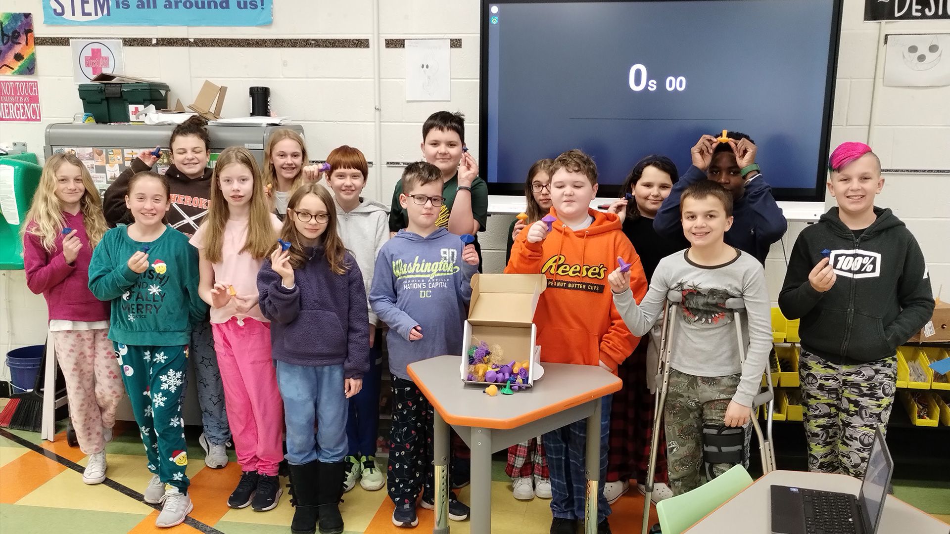 A group of students holding their 3D printed spinning top models.