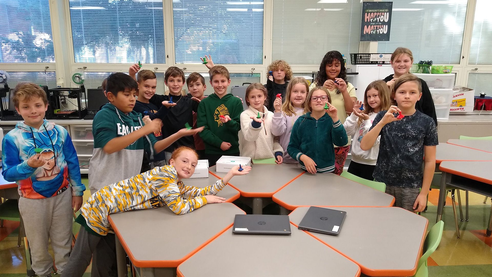 A group of students holding their 3D printed spinning top models.