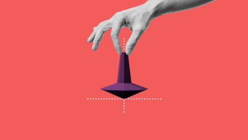 A hand holding the tip of a spinning top.