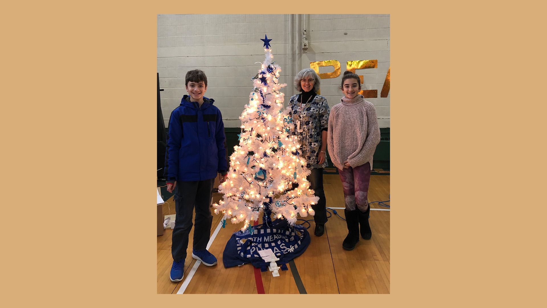 Teacher Michele Brezovec stood with 2 students and a tree decorated with 3D printed ornaments.