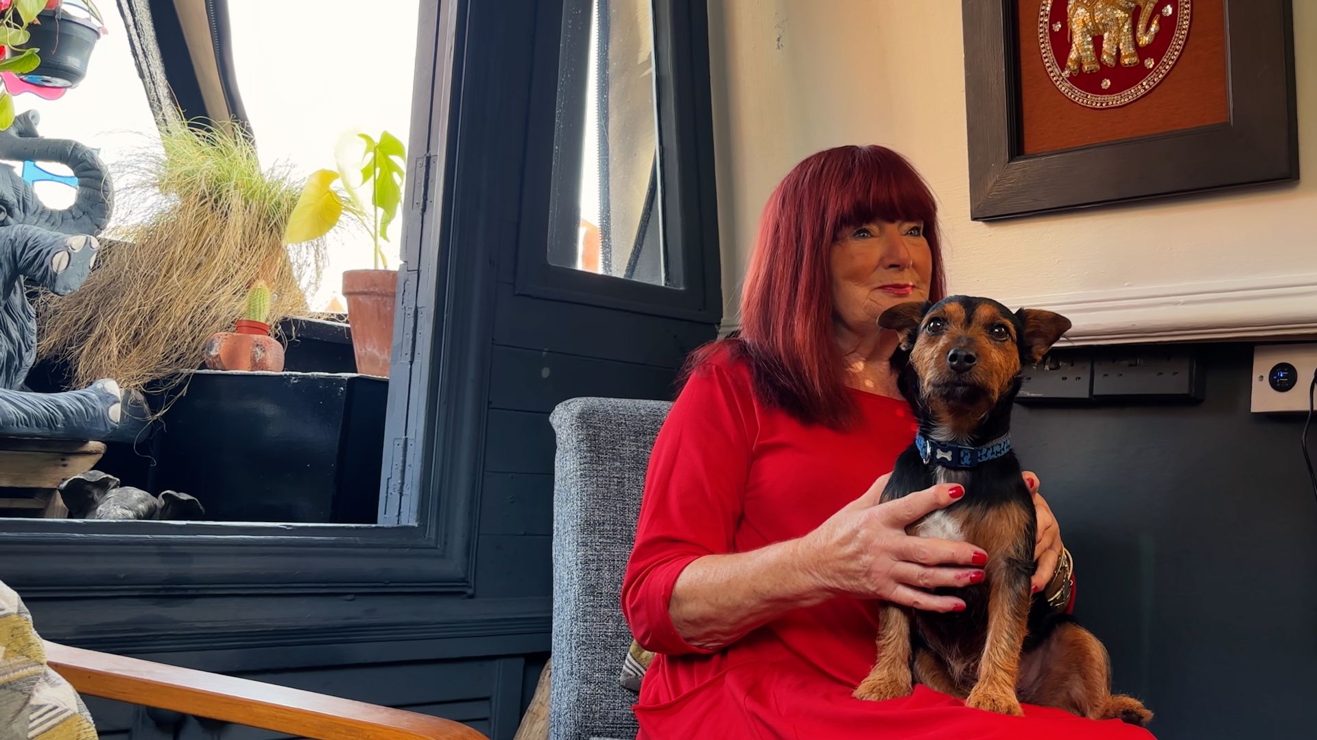 Make:able Champion, Cath, sitting on a chair with her dog on her lap.