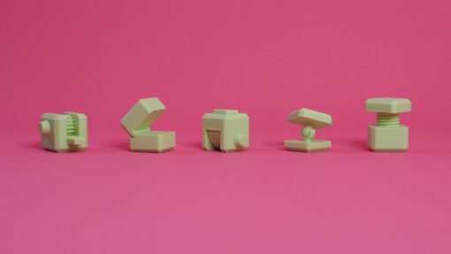 5 3d printed mechanism cubes on a bright pink background.