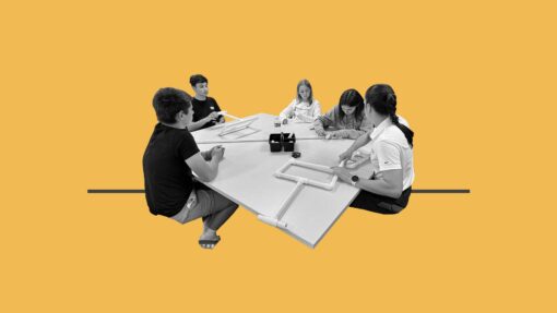Students sat around a table creating prototypes of an assistive ipad holder