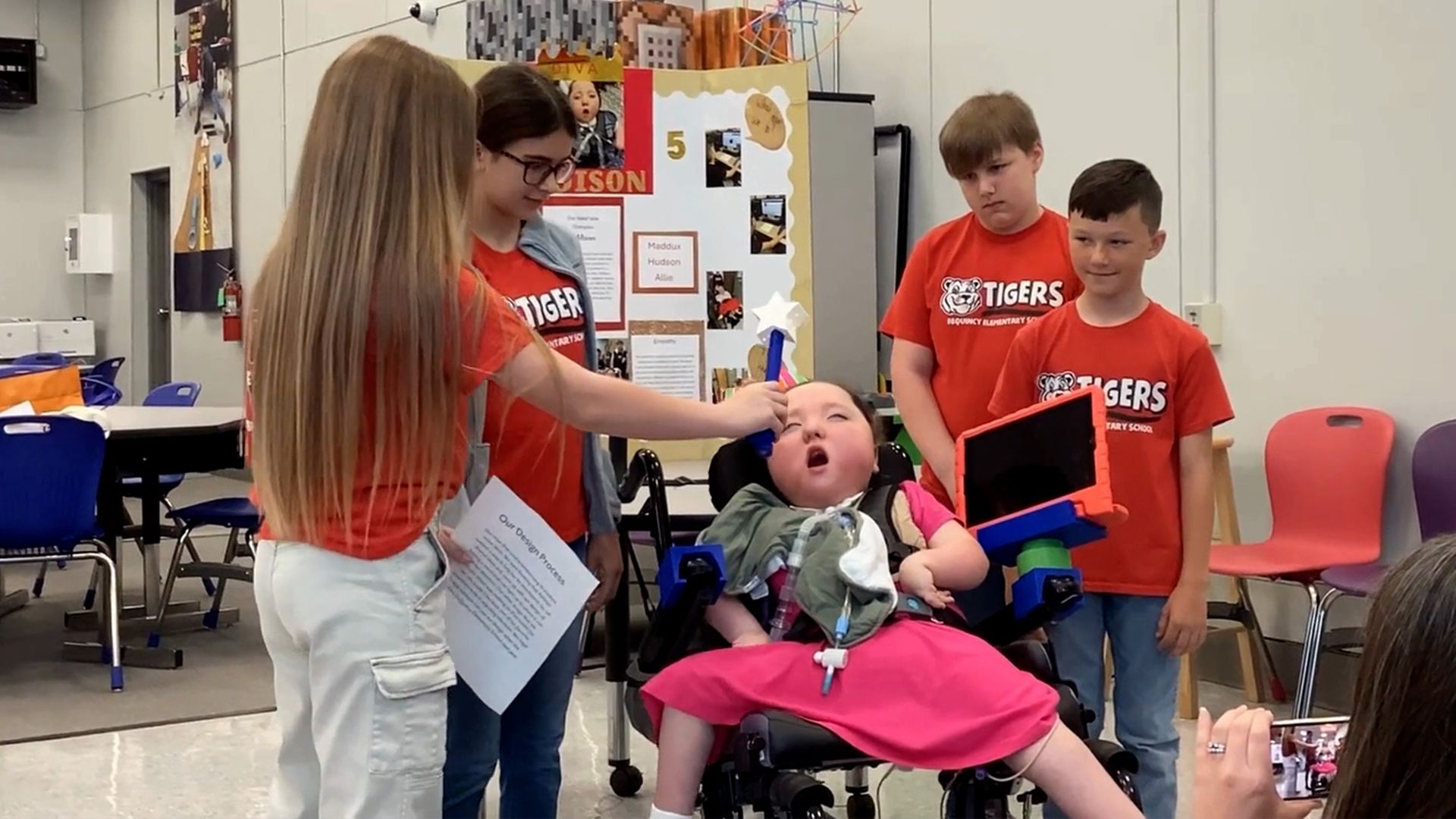 A team of students presenting their 3D printed ipad holder and light wand to their end user.