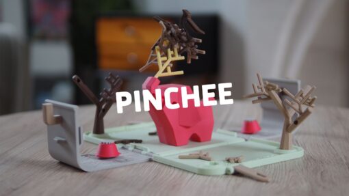 A 3d printed dexterity game called Pinchee, on a table. The game involves stacking twigs on top of an elephant, using birds as the carrying tools.