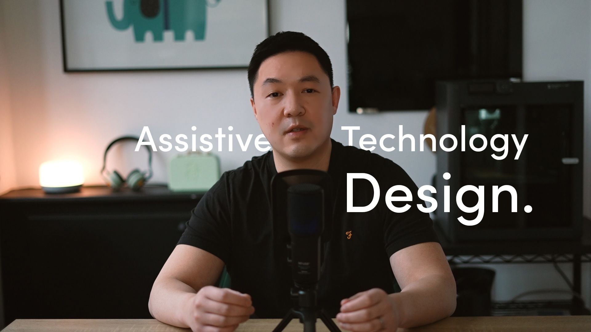 PrintLab Co-Founder, Jason Yeung, sat at a desk with a microphone. The title 'Assistive Technology Design' overlaid in white text.