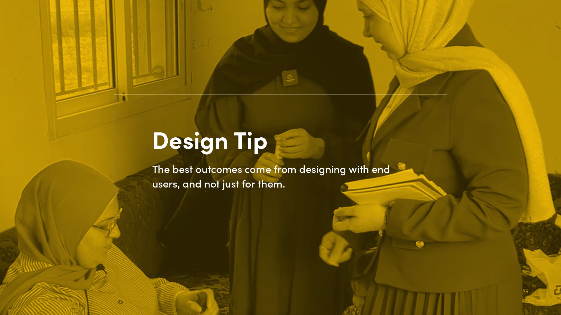 Two team members stand beside Karima as she tests a 3D printed assistive device while seated on a couch. The students observe and gather feedback from her during testing. A yellow overlay with white text reads, “The best outcomes come from designing with end users, not for them.”