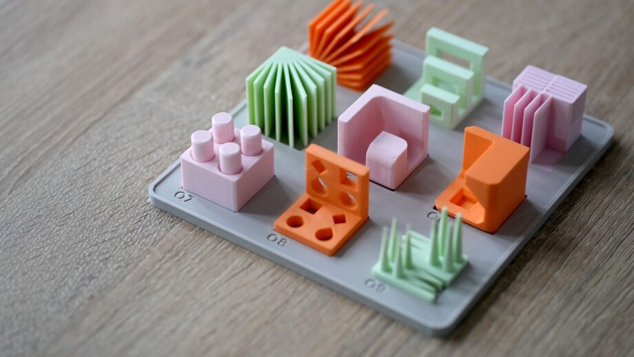 3D printed design principles model set on a base, showing colourful test models demonstrating overhangs, holes, and geometry features