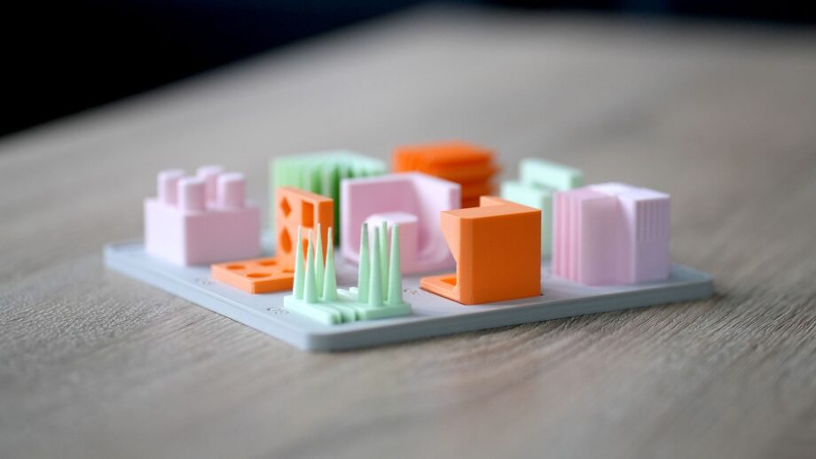 Close-up of 3D printed design principles model set with small test geometries in pastel colours on a grey base