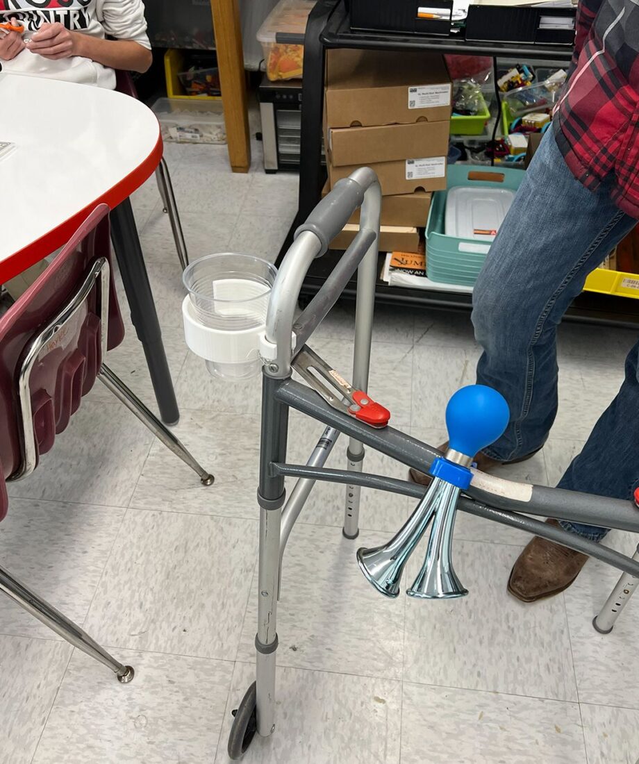 3D printed cup holder attached to a walker, designed by students to support independent living